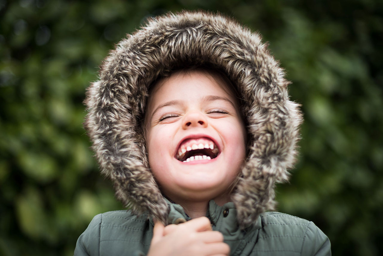 Young girl laughing with hood up