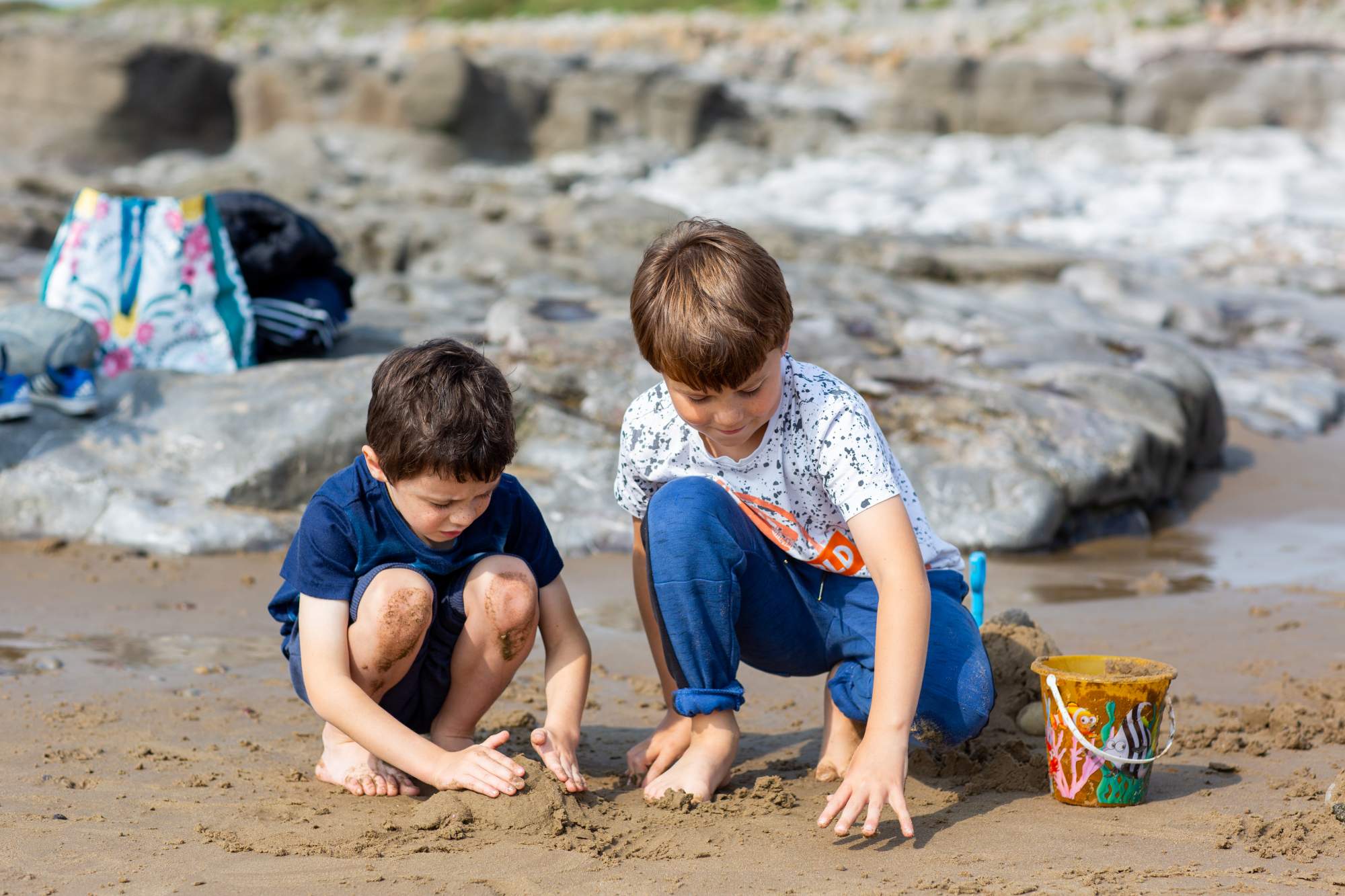 Two brothers making a sandcastle on the beach