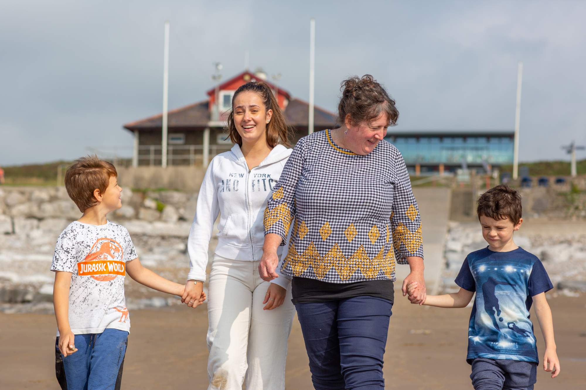 Family on the beach holding hands and laughing