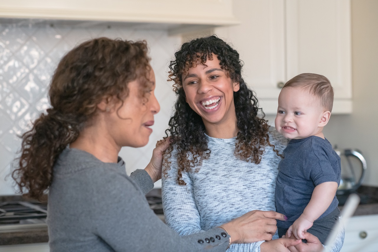 Two women smiling at boy